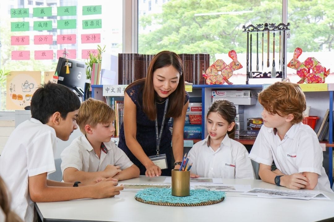 Teacher guiding a small group of EtonHouse Broadrick students during a classroom discussion.