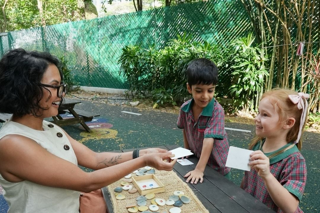 Teacher engaging young EtonHouse Broadrick children in an outdoor learning activity.