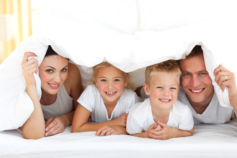 Happy family playing together on a bed at home